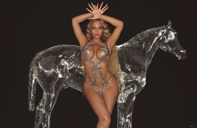 Beyoncé: Wears a daring metallic bodysuit with shiny details that accentuate her figure, while holding…