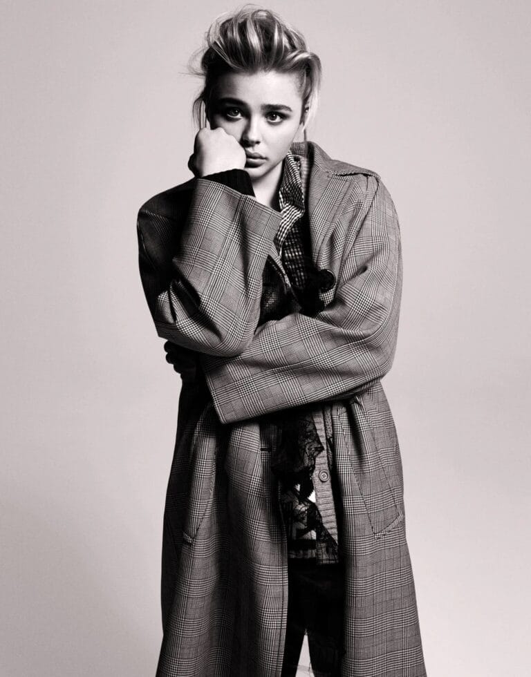 Chloë Grace Moretz: Luce un abrigo de cuadros en tonos gris y negro, con una blusa oscura…