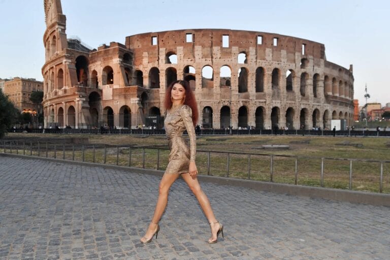 Zendaya: Walks with confidence, wearing a fitted gold dress that highlights her figure. She completes the…