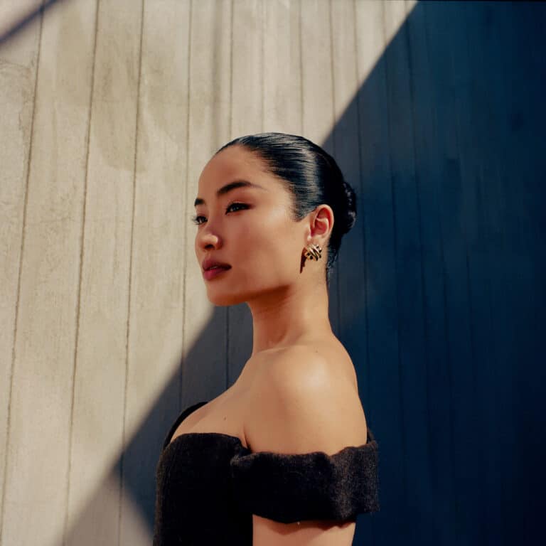 Anna Sawai: The shoes can't be seen in the image. She wears a black dress with…