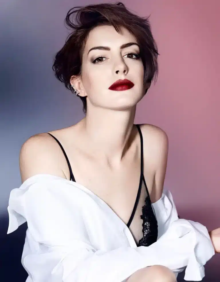 Anne Hathaway: Her hair is short and tousled. She wears a black lace set under a…