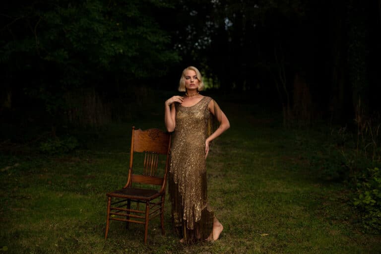Margot Robbie: Wears a long gold dress with sparkly details and fringe on the sleeves. No…