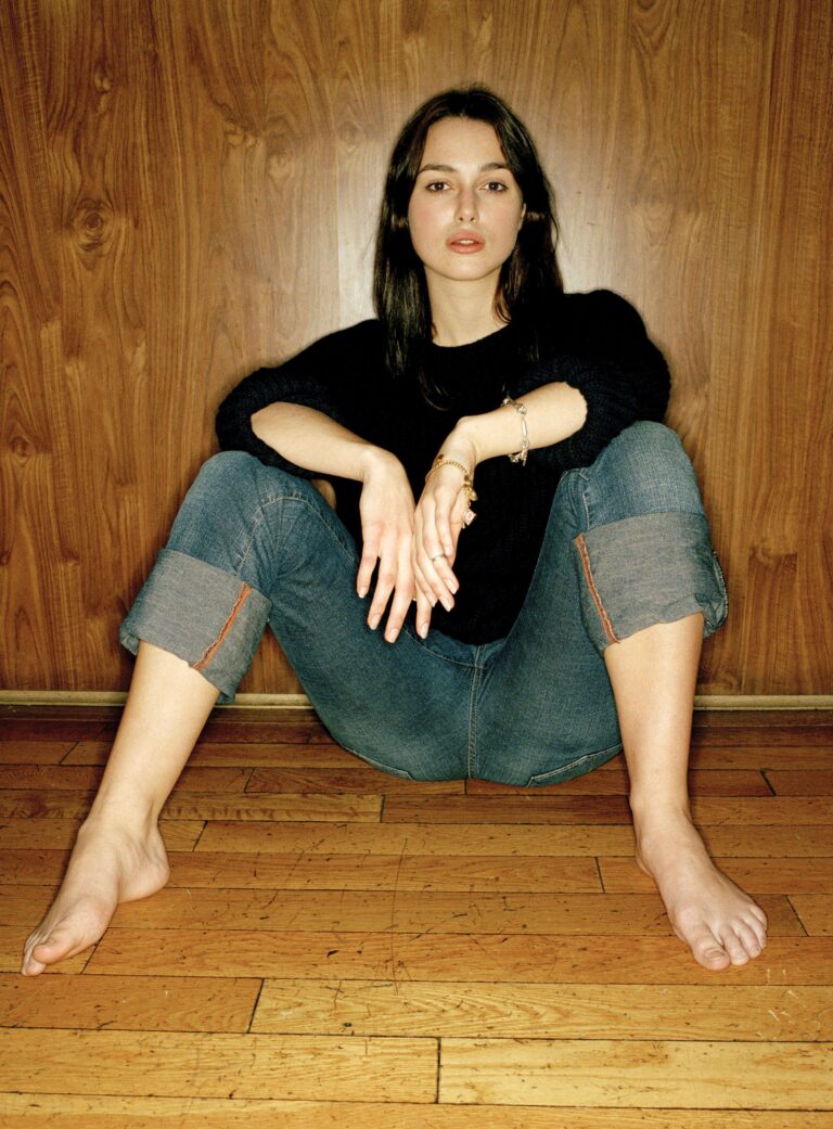 Keira Knightley: No lleva calzado. Viste un suéter negro y pantalones vaqueros con las piernas remangadas.…