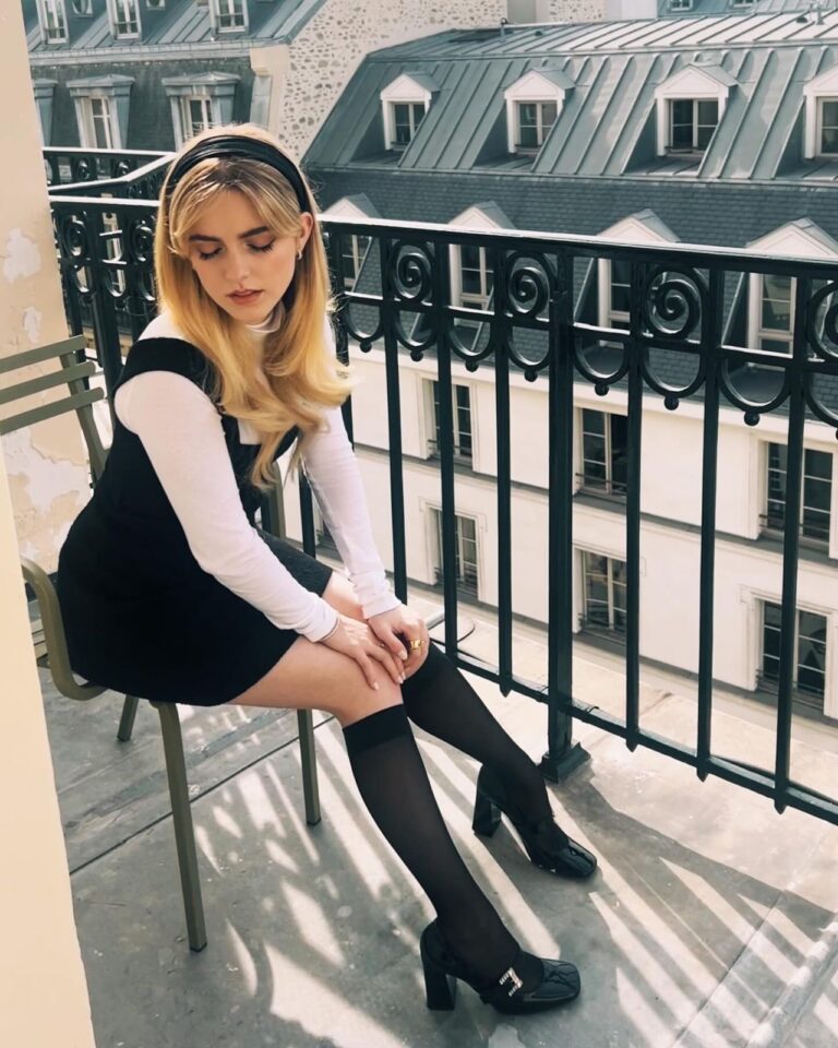 Mckenna Grace: Wears a black dress over a white long-sleeve top. Pairs it with black tights…