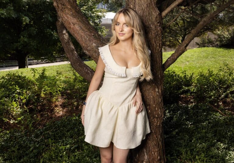 Mckenna Grace: Wearing a short cream-colored dress with lace details at the neckline.…