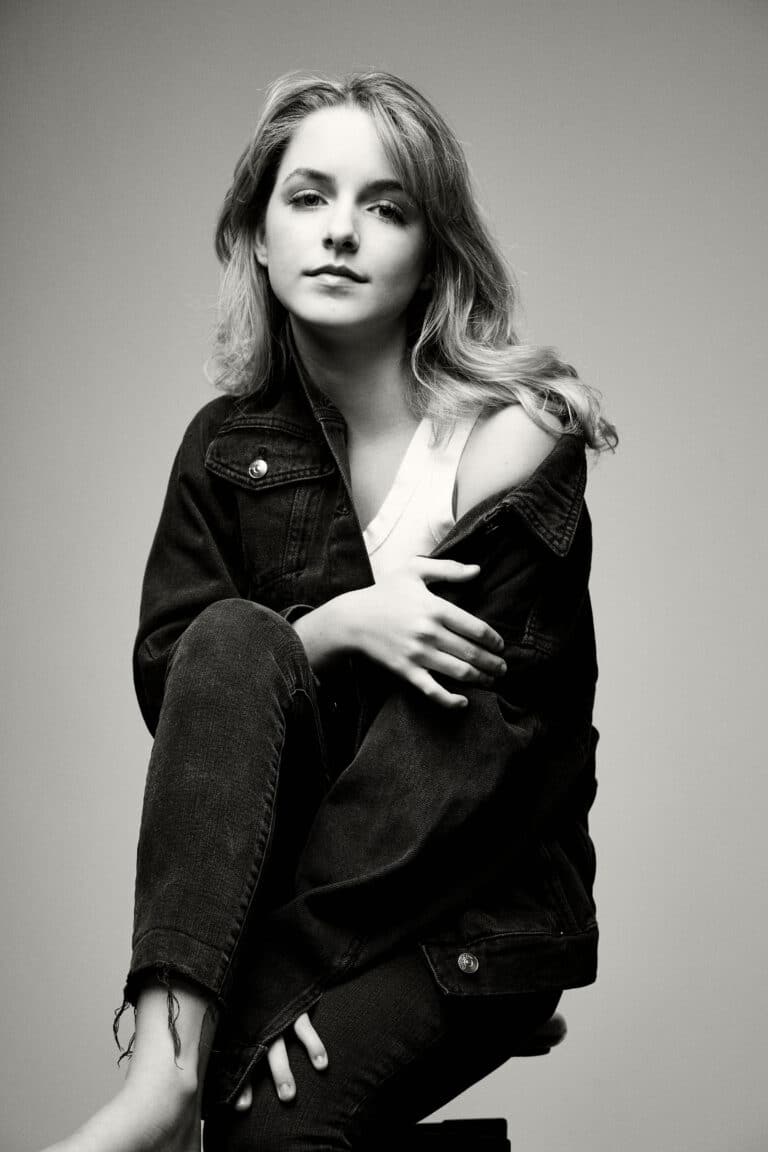 Mckenna Grace: Wears a dark denim jacket over a light top. Barefoot and…