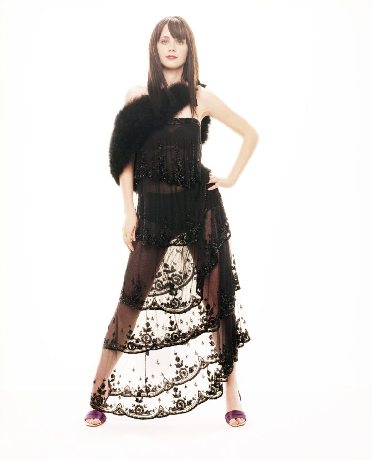 Zooey Deschanel: Lleva un vestido largo y transparente con detalles bordados en negro. Un chal negro…