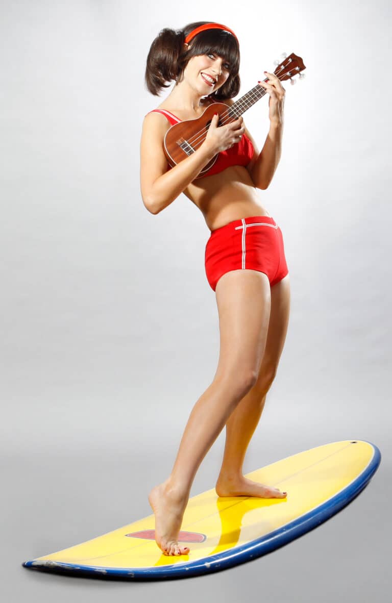 Zooey Deschanel: Barefoot. Wears a red bikini set with white details and a…