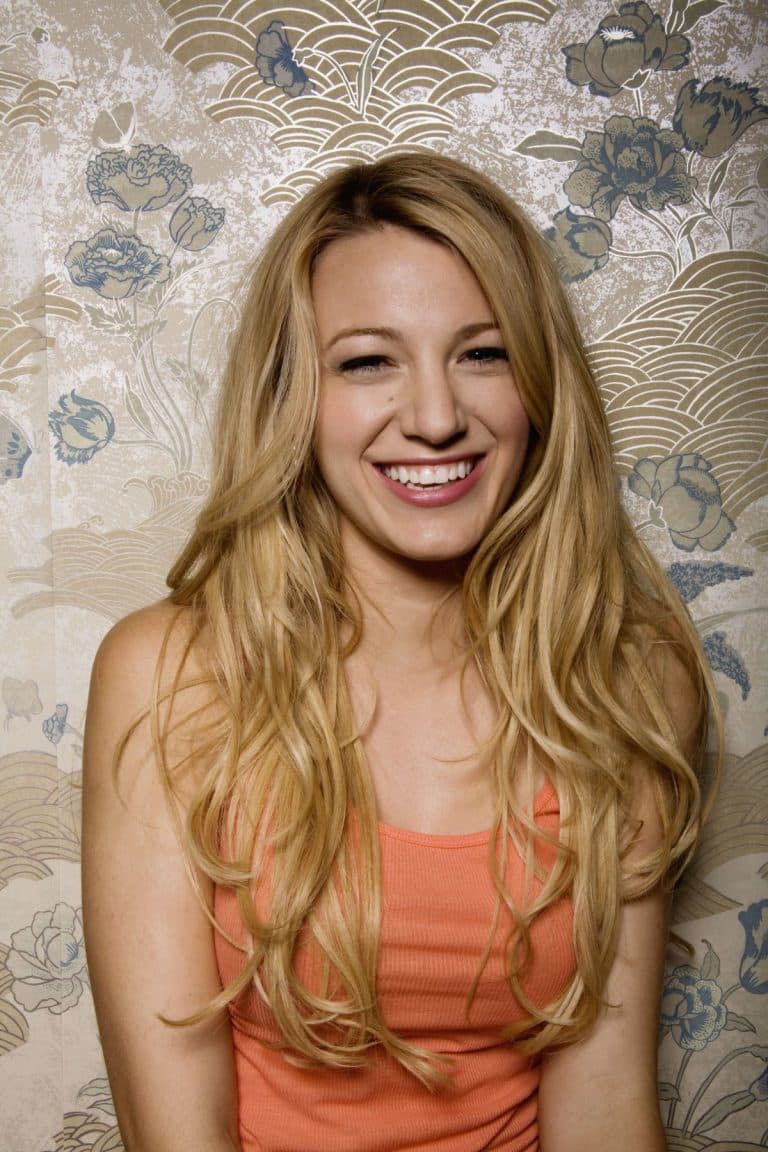 Blake Lively: Footwear isn't visible. She wears an orange sleeveless top.…
