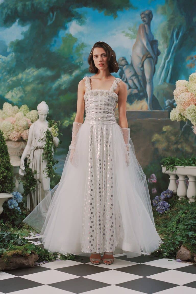 Margaret Qualley: Lleva un vestido largo blanco con lentejuelas plateadas y transparencias, complementado con guantes de…