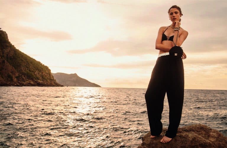Margaret Qualley: Barefoot, no shoes. Wears a black top and…