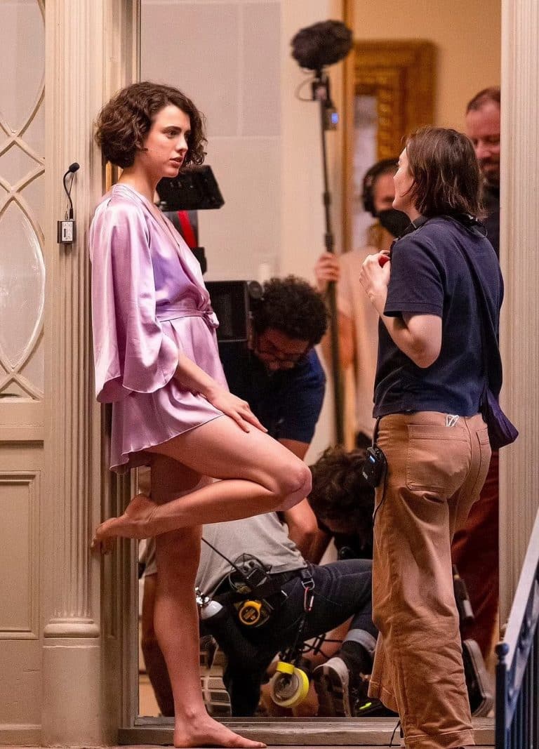 Margaret Qualley: Wears a short bright lilac kimono, barefoot. Curly hair and…