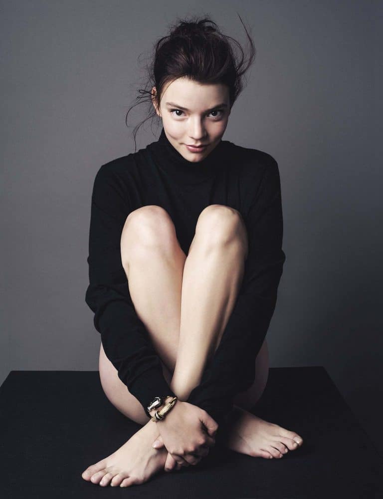 Anya Taylor-Joy: Wears a long-sleeved black sweater and is barefoot. As an accessory, she has a…