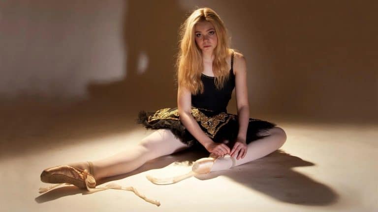 Elle Fanning: Wearing a black tutu with gold details and a black leotard, the footwear consists…