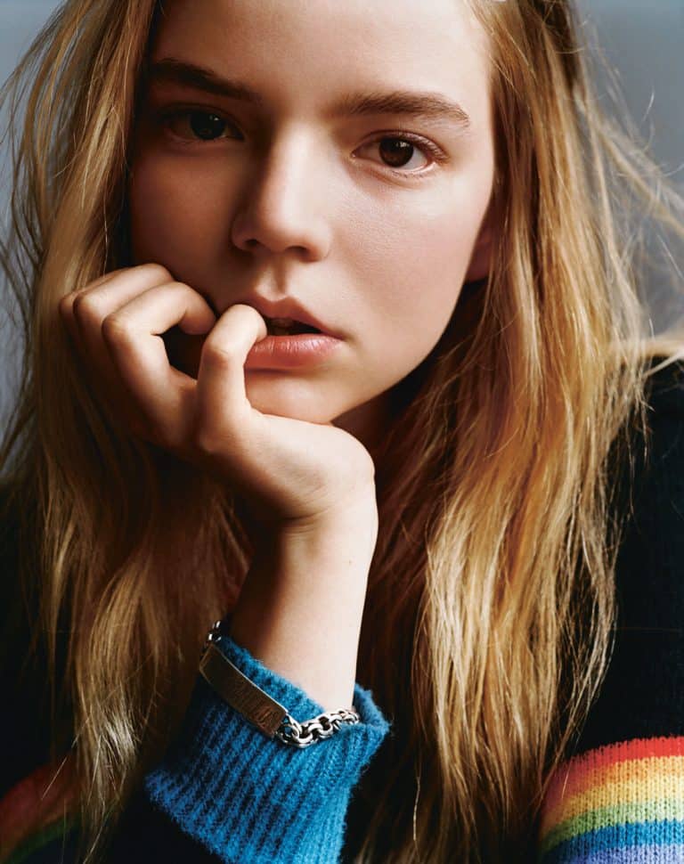 Anya Taylor-Joy: No footwear shown. The visible clothing is a black sweater with…