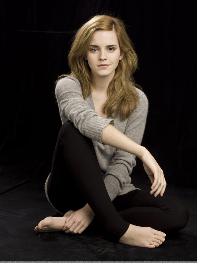 Emma Watson: Lleva un suéter gris de manga larga y unos leggings negros. Está descalza y…
