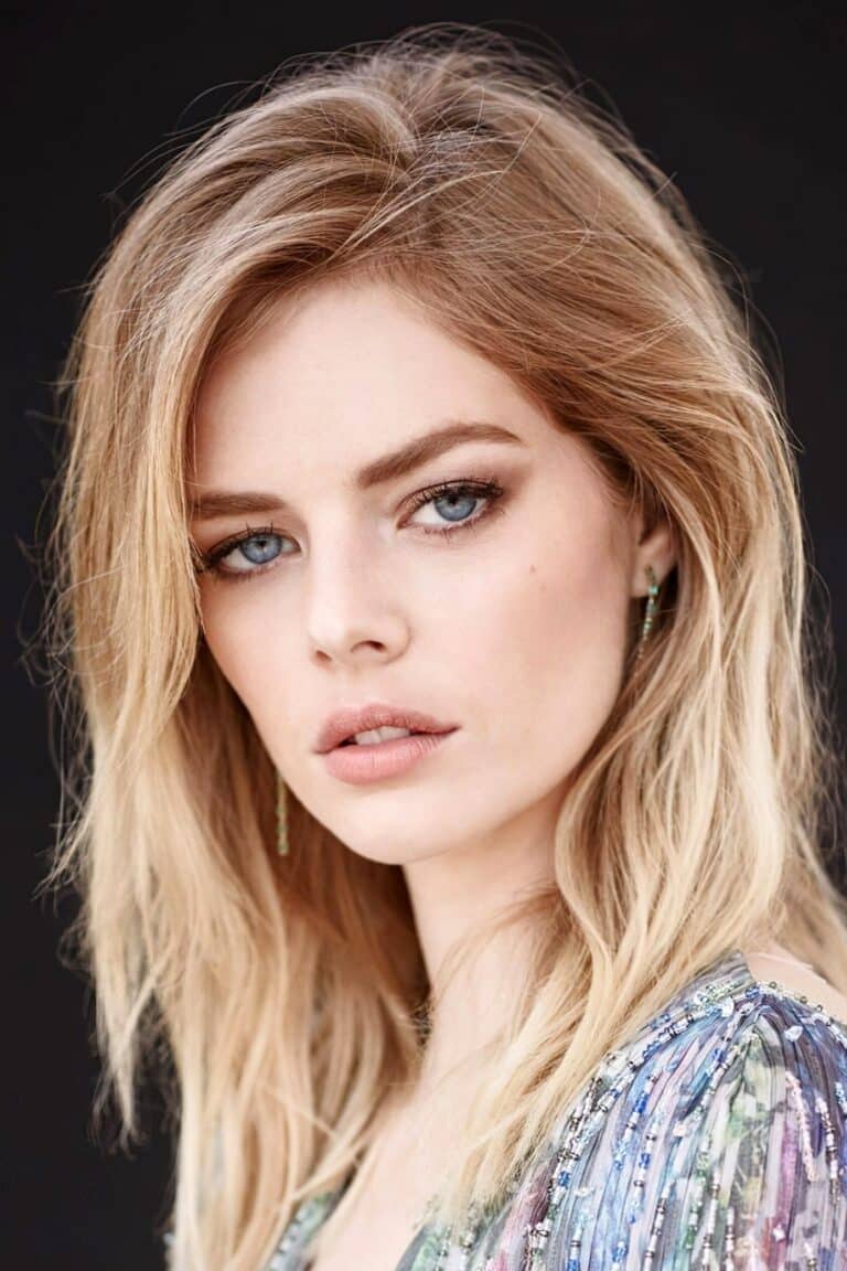 Samara Weaving: Loose blonde hair and natural makeup highlighting blue eyes. Wears a piece with…