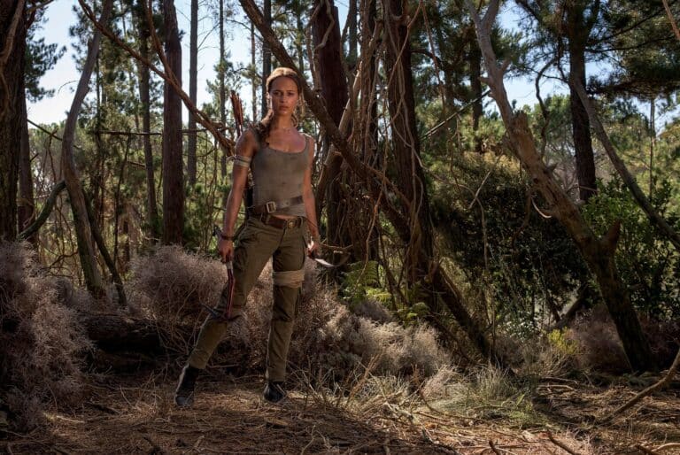 Alicia Vikander: Wears a fitted, worn-looking tank top with green cargo pants. In…