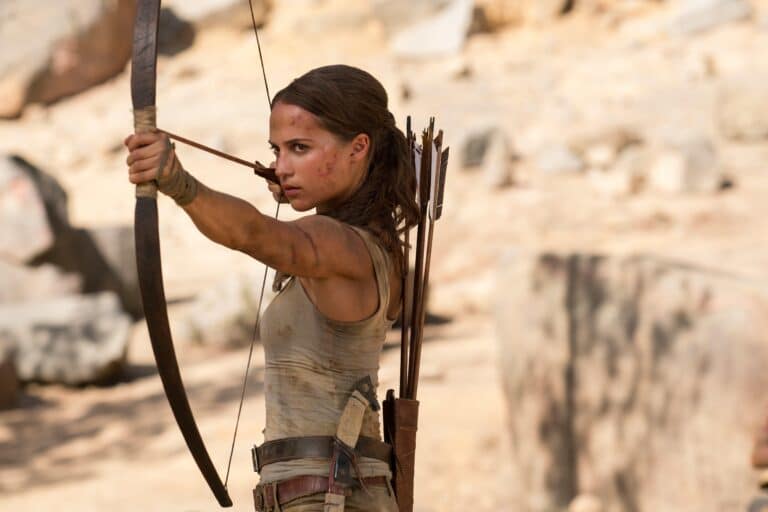 Alicia Vikander: Focused and aiming an arrow with a determined expression. Wearing a sleeveless top&hellip;