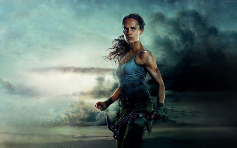 Alicia Vikander: Against a cloudy sky backdrop, wearing a gray tank top and…