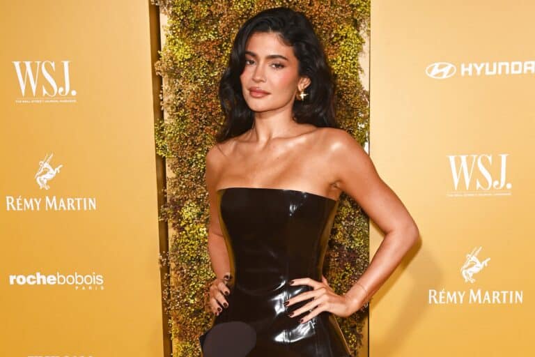 Kylie Jenner: Luce un vestido negro sin tirantes de material brillante que resalta su figura. Lleva…