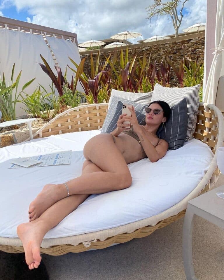 Lucy Hale: Enjoying the sun at an outdoor lounge, in a brown bikini and…