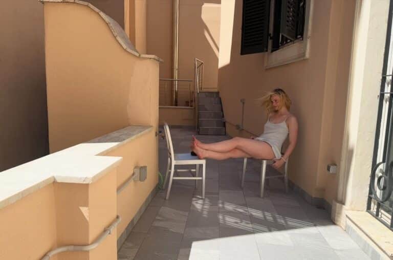 Elle Fanning: Sitting in an outdoor chair, wearing a white camisole set. The…