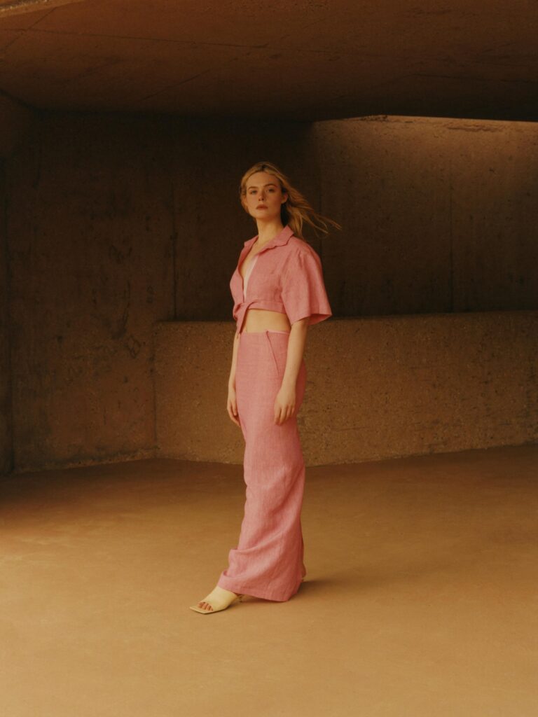 Elle Fanning: Wearing a pink linen set, with a short-sleeved blouse tied at the…