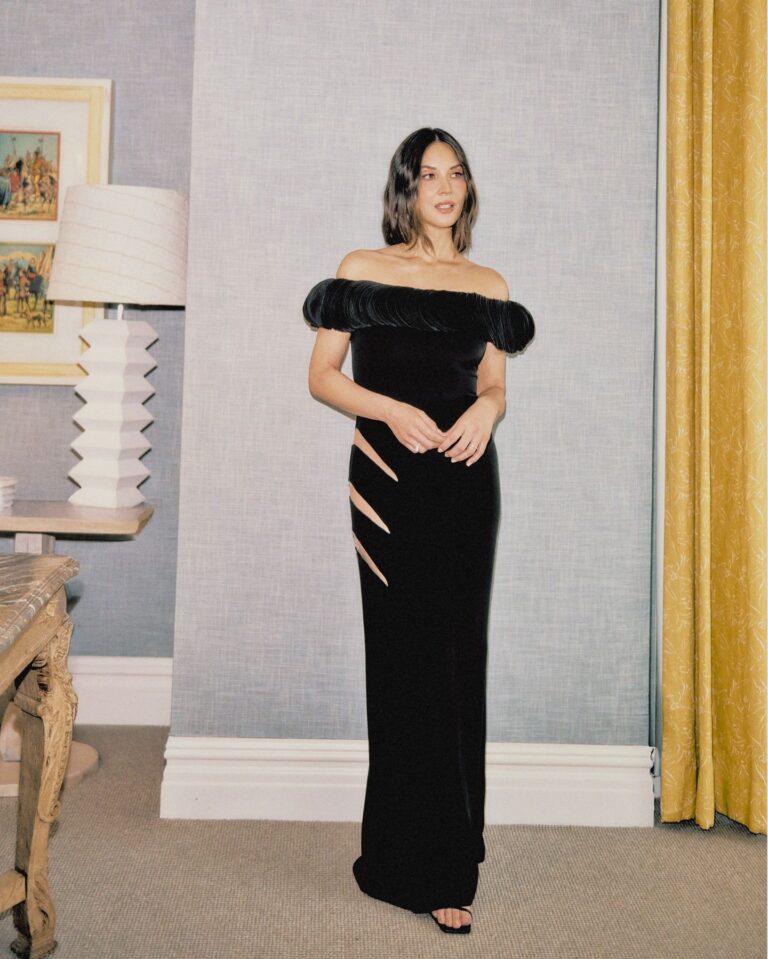 Olivia Munn: Wearing an elegant long black gown with a boat neckline and…