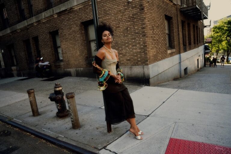 Zazie Beetz: On an urban street next to a brick building, wearing a matching outfit with…