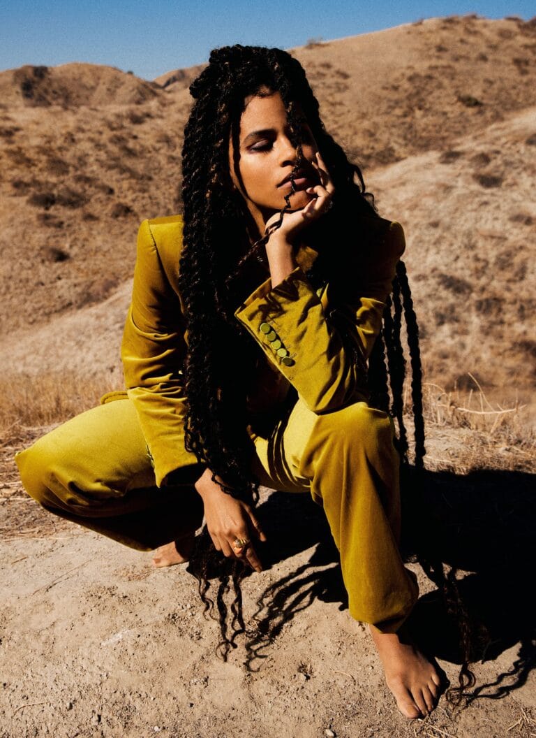 Zazie Beetz: Wears a bright mustard suit and has her hair in long braids.…
