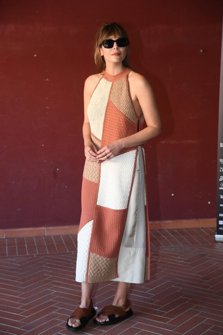 Elizabeth Olsen: Wears a sleeveless long dress with a geometric pattern in beige and…
