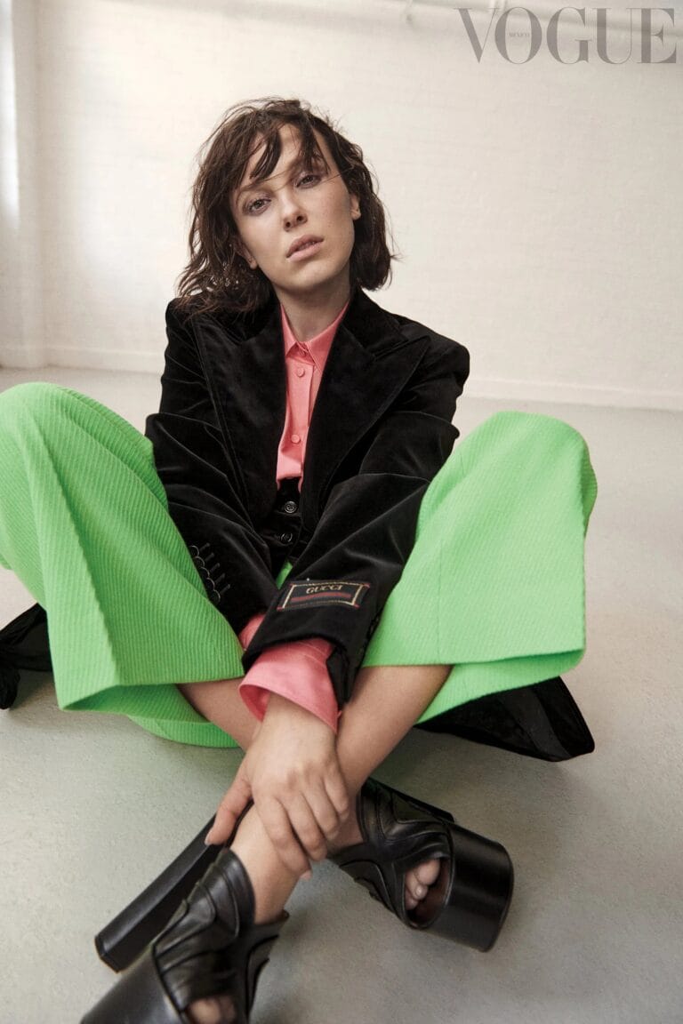 Millie Bobby Brown: Wears a black coat over a pink shirt, paired with wide green pants.…