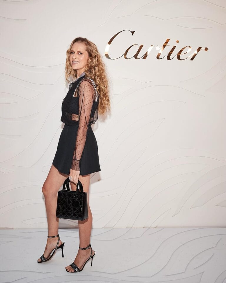 Teresa Palmer: Wears a short black dress with sheer tulle sleeves and polka dots. Pairs it with sandals…