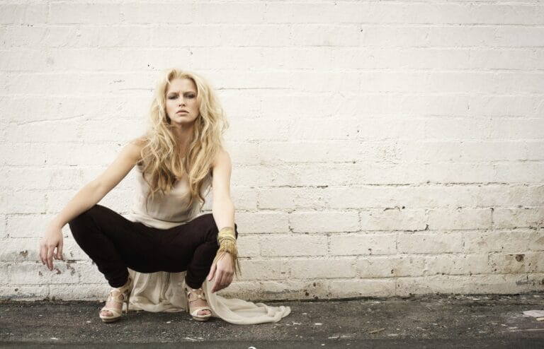 Teresa Palmer: Long loose hair, wearing a light blouse and dark pants. Wears several…