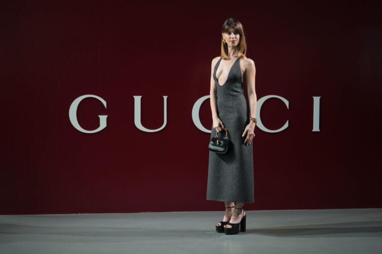 Daisy Edgar-Jones: Long gray dress with a deep neckline, tall platform shoes and gold bracelet…