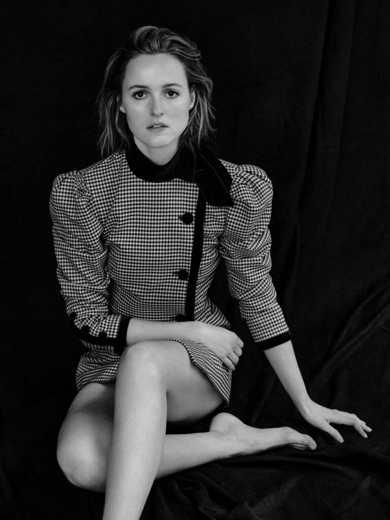 Renate Reinsve: Wears a plaid dress with dark buttons and structured sleeves. Is…
