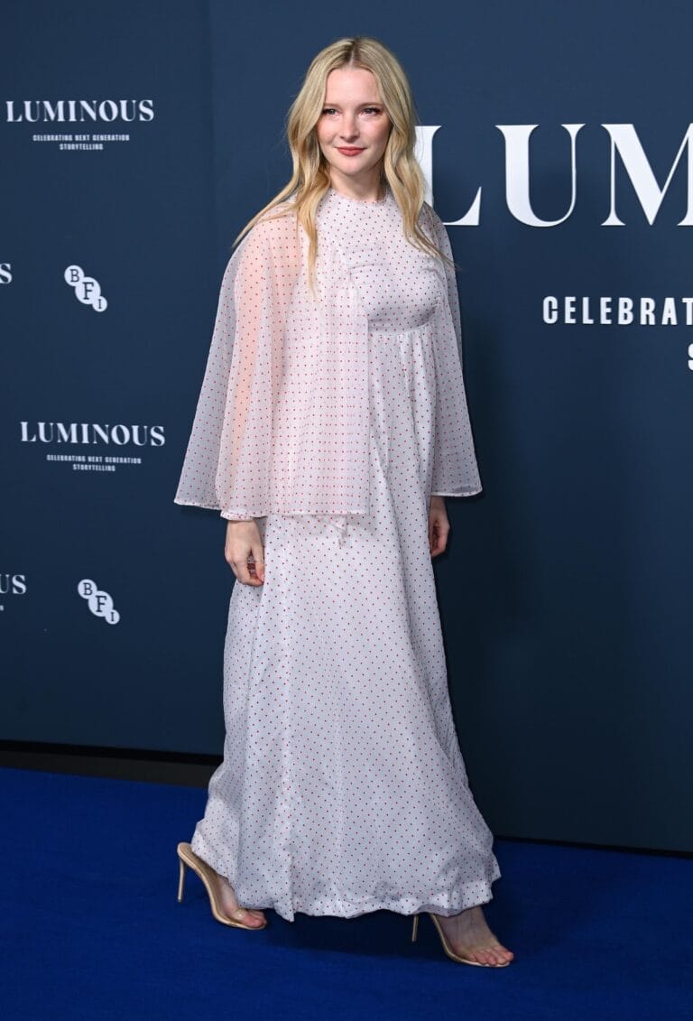 Morfydd Clark: Viste un vestido largo blanco con lunares rojos y una capa semitransparente a juego.…