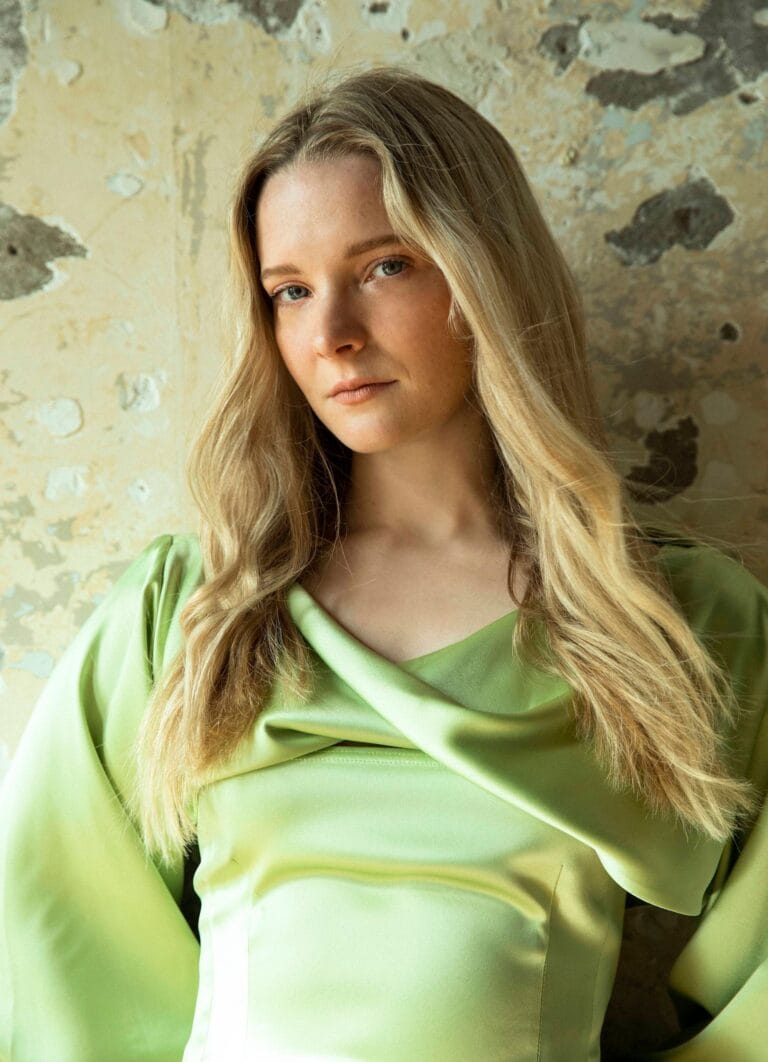 Morfydd Clark: Luce una blusa verde claro de tela satinada con un diseño elegante y drapeado.…