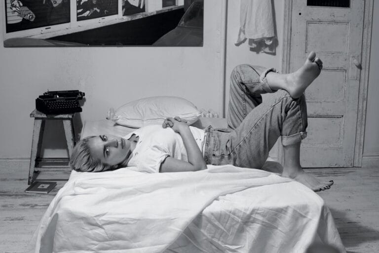 Lady Gaga: In a simply decorated room, with a typewriter on a…
