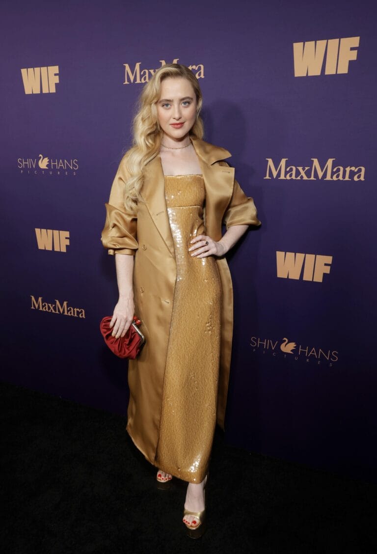 Kathryn Newton: Shines in a bright gold dress paired with a matching coat. She wears sandals…
