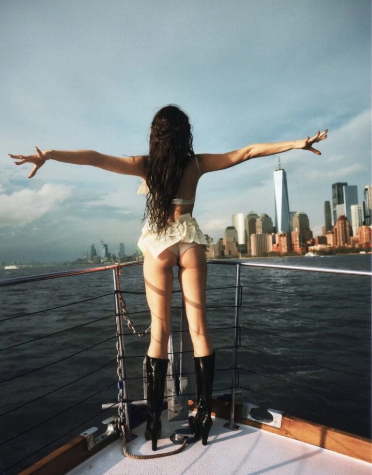 Margaret Qualley: Long hair worn loose, wearing black high-heeled boots and a lingerie…