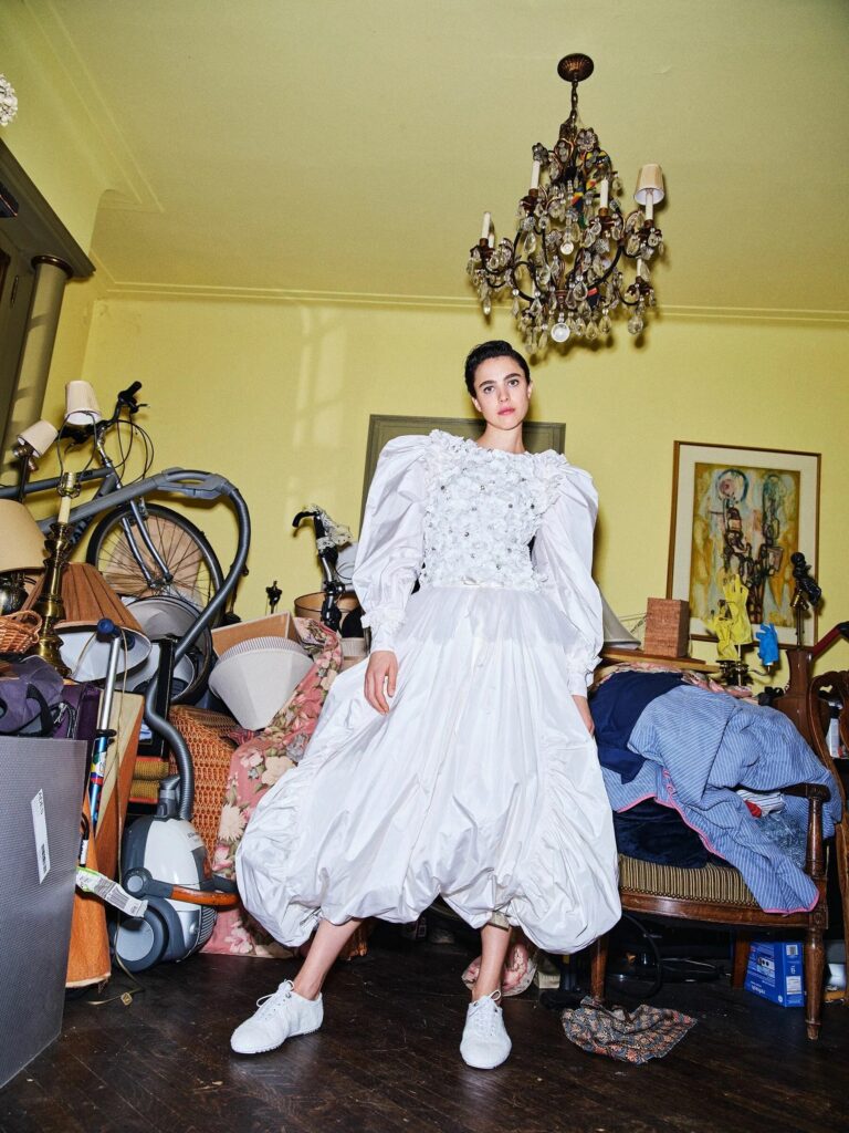 Margaret Qualley: Wears a white dress with floral details on the bodice and puffed sleeves.…