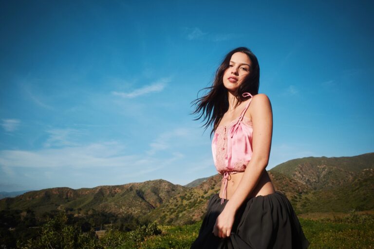 Olivia Rodrigo: Wearing a pink top with lace details and a voluminous black skirt. Not…