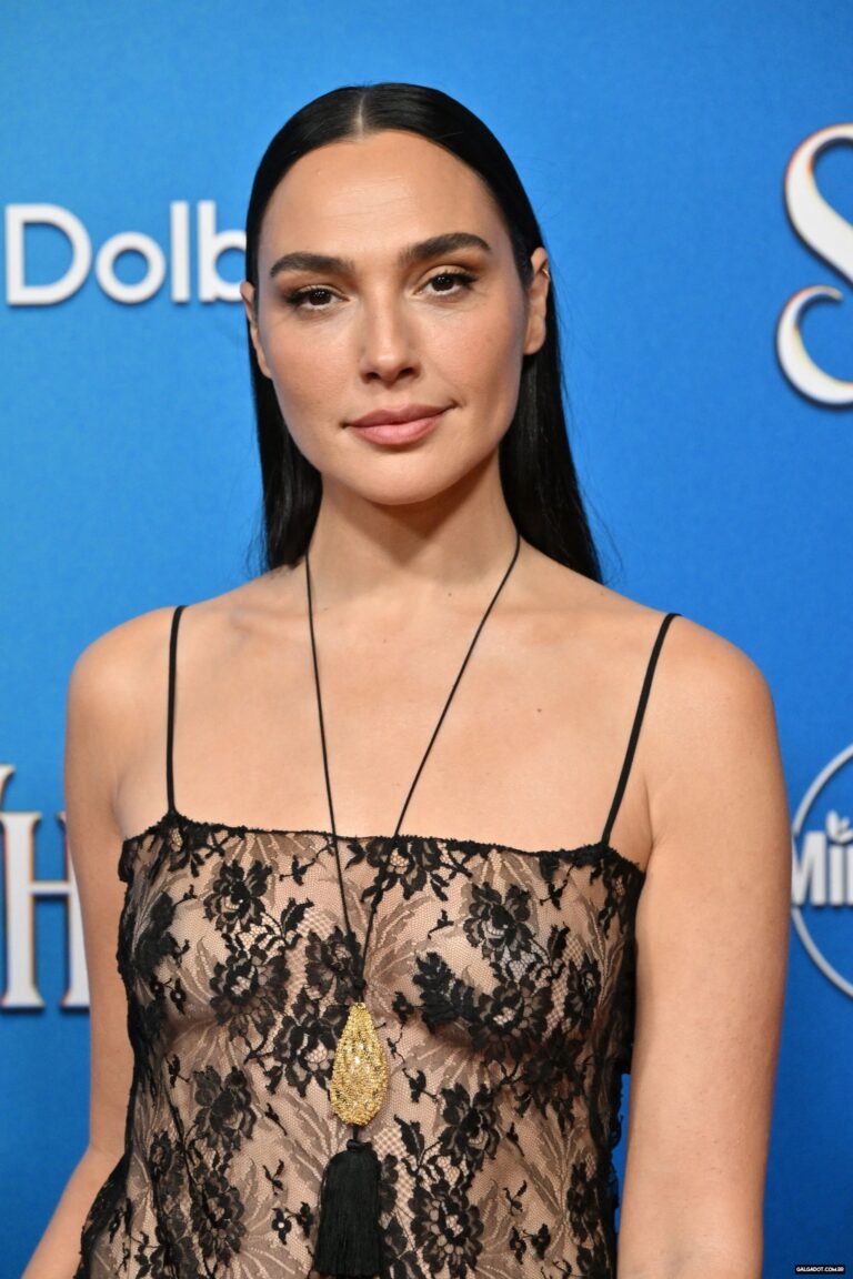 Gal Gadot: Straight black hair, wearing a black lace dress with thin straps. A…