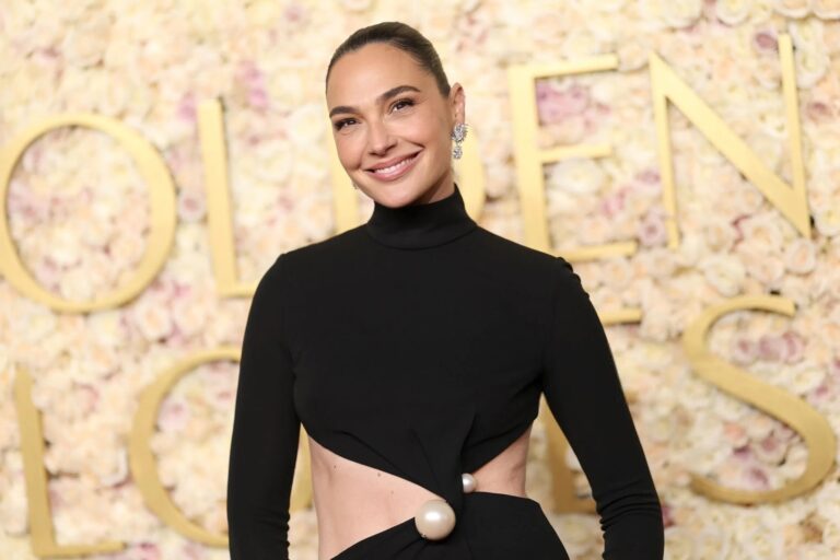 Gal Gadot: Wears an elegant long-sleeve black dress with an asymmetric design that leaves…