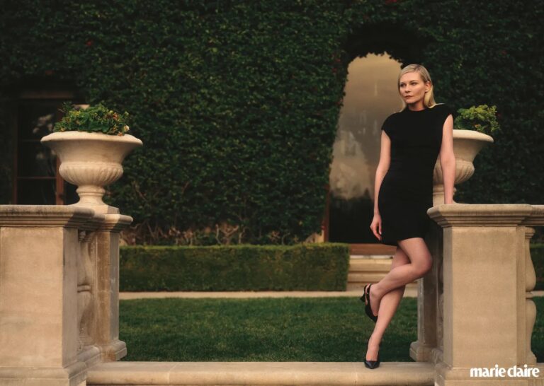 Kirsten Dunst: Wears an elegant fitted black dress and dark heels. Her hair is blonde and…