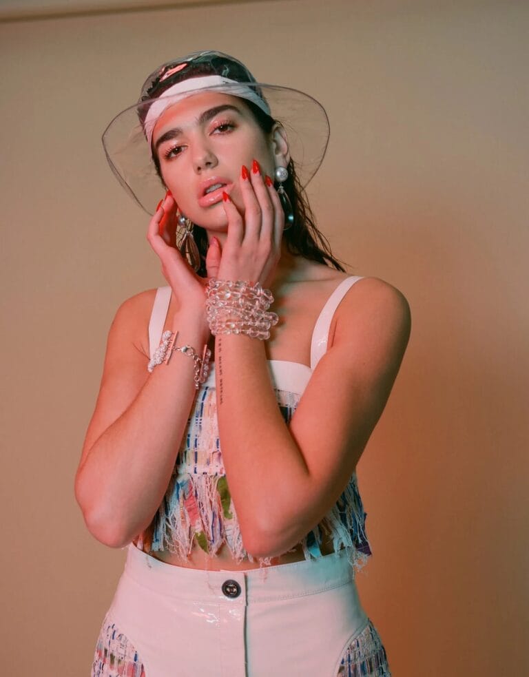 Dua Lipa: Luce un top corto de flecos multicolores que destaca su figura, combinado con una…