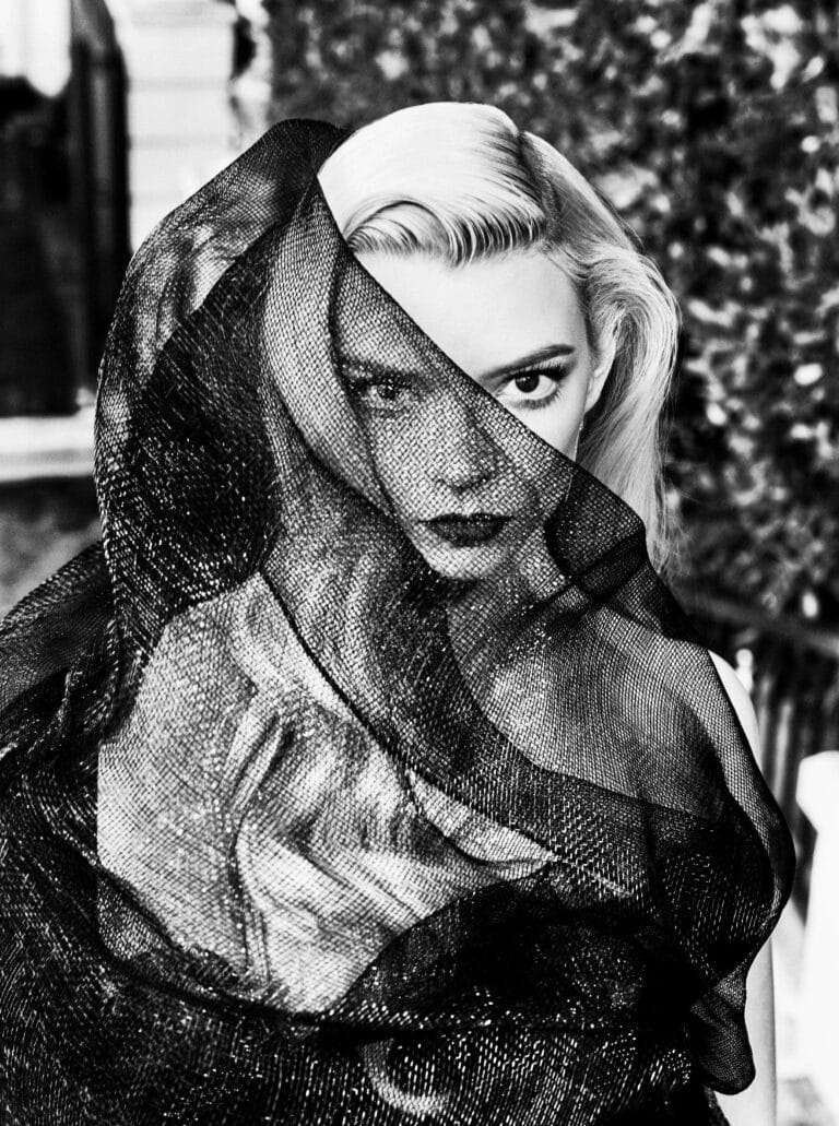 Anya Taylor-Joy: Wears a sheer black veil wrapping her face, creating a mysterious effect and…