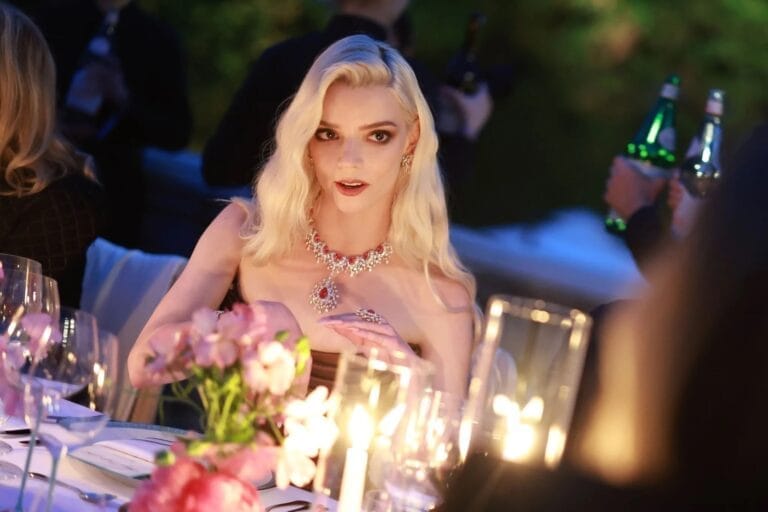 Anya Taylor-Joy: Wears an elegant strapless dress in a night setting, surrounded by candles and flowers…